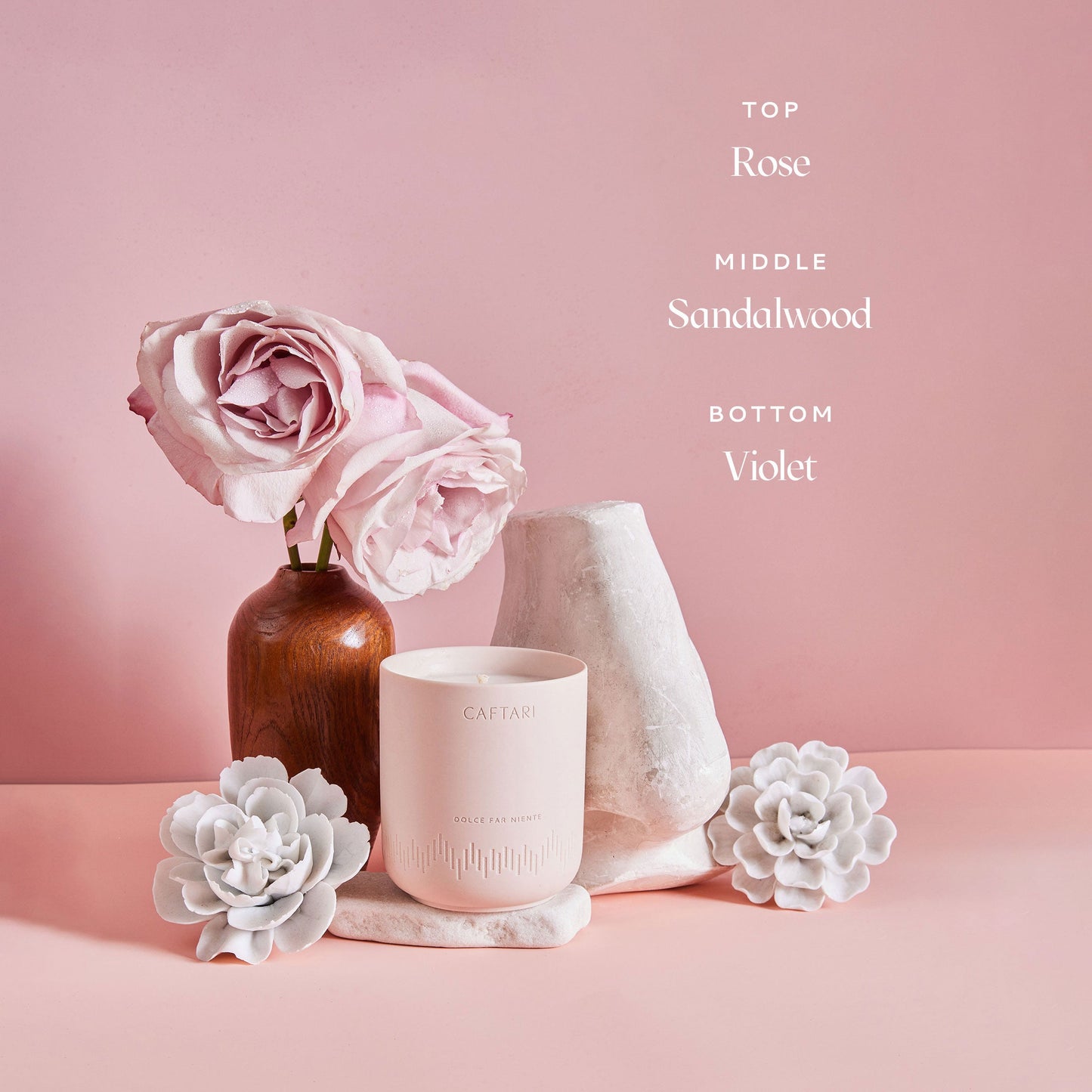 Candle with flowers on a pink background