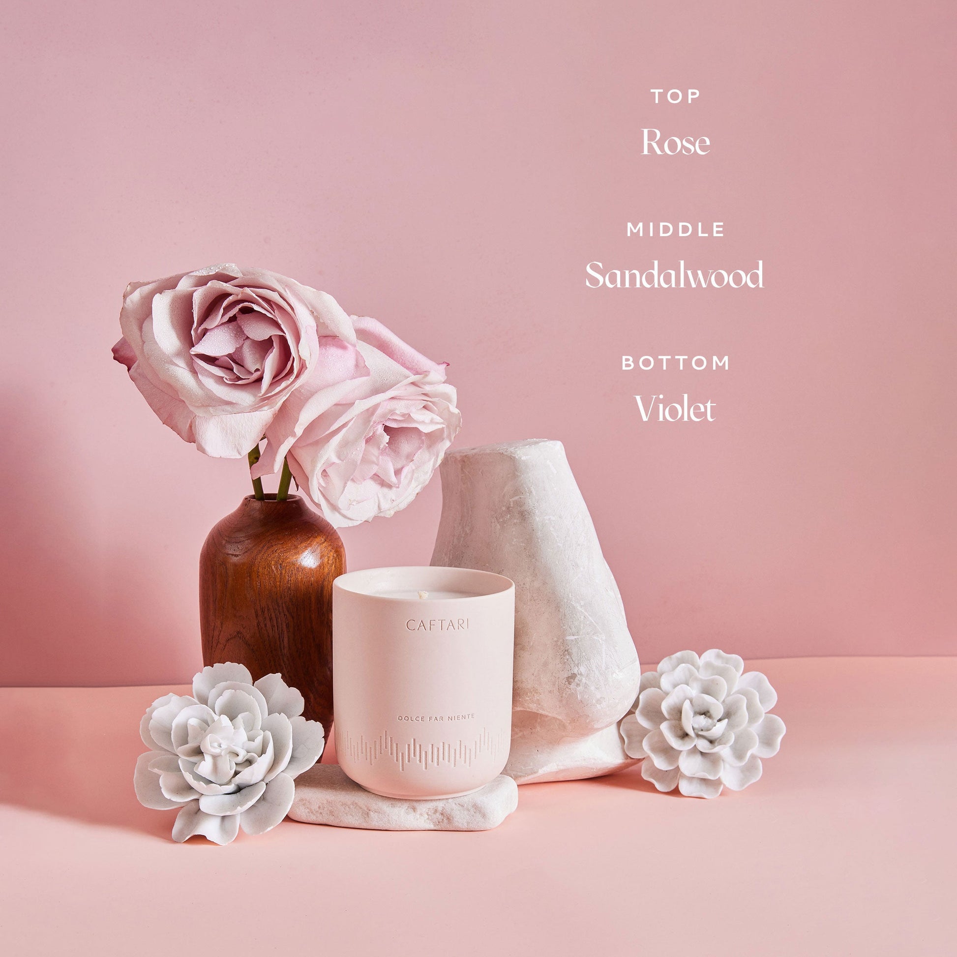 Candle with flowers on a pink background