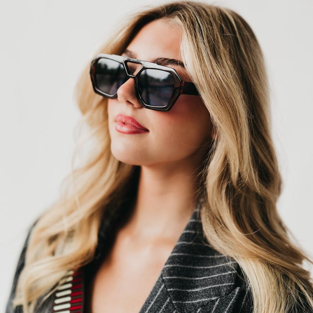 Woman wearing sunglasses with a neutral background