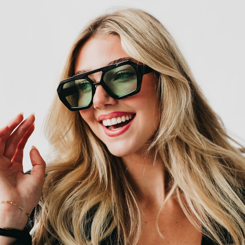 Woman wearing sunglasses with a neutral background