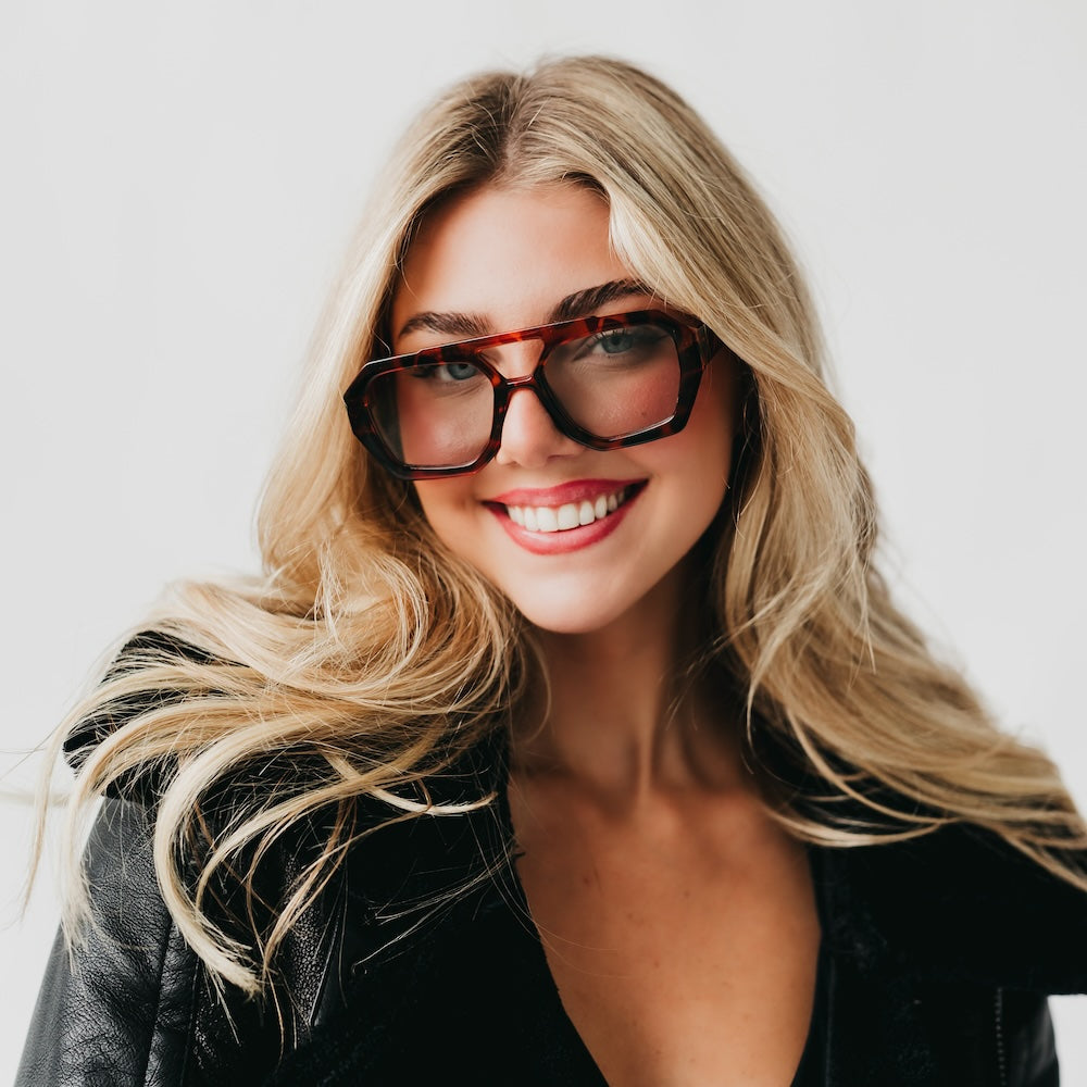 Woman wearing glasses with a plain background