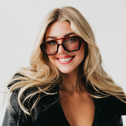 Woman wearing glasses with a plain background