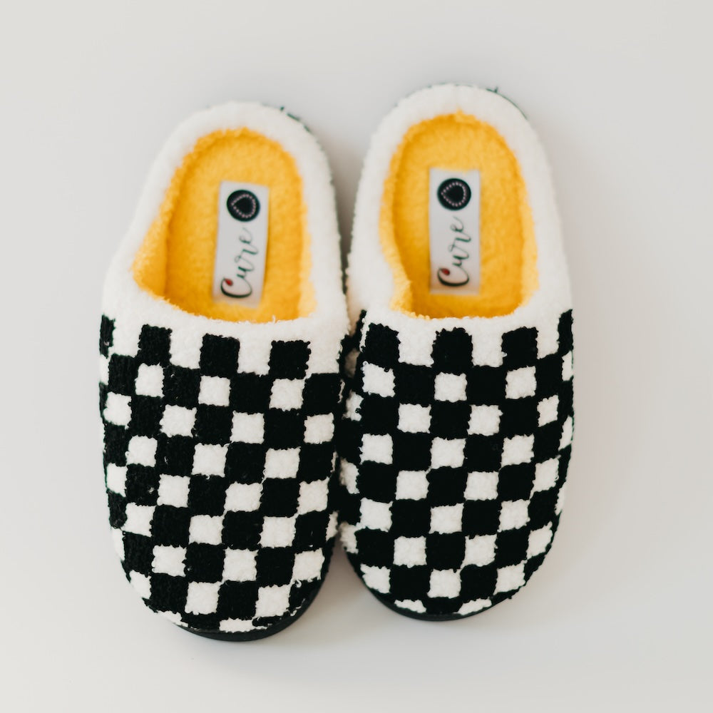 Pair of checkered slippers with yellow interior on a white background