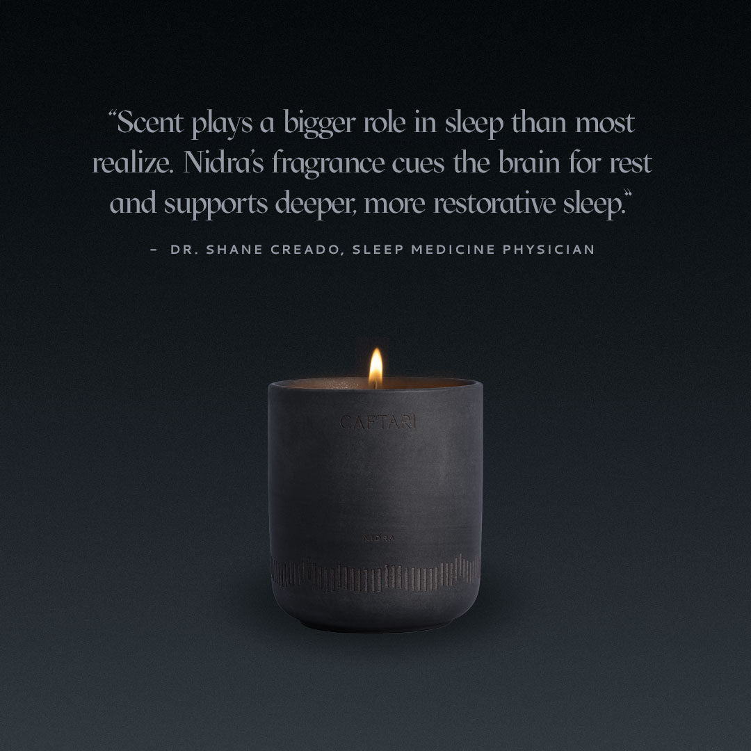 Caftari Nidras fragrance candle. Black candle with a quote from Dr. Shane Creado on a dark background