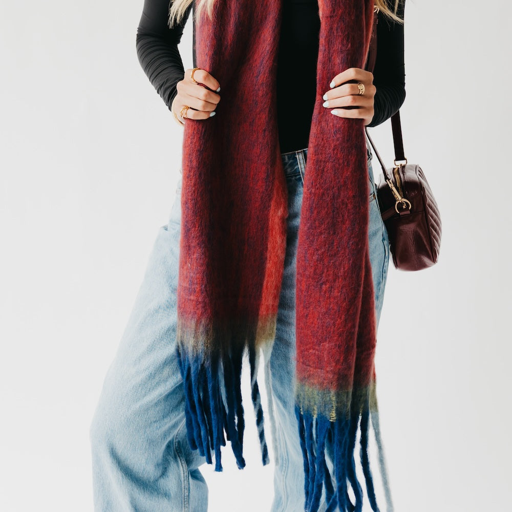 Person wearing a red and blue plaid scarf with a plain background