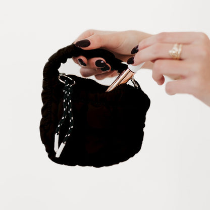 Person holding a black handbag with a white background