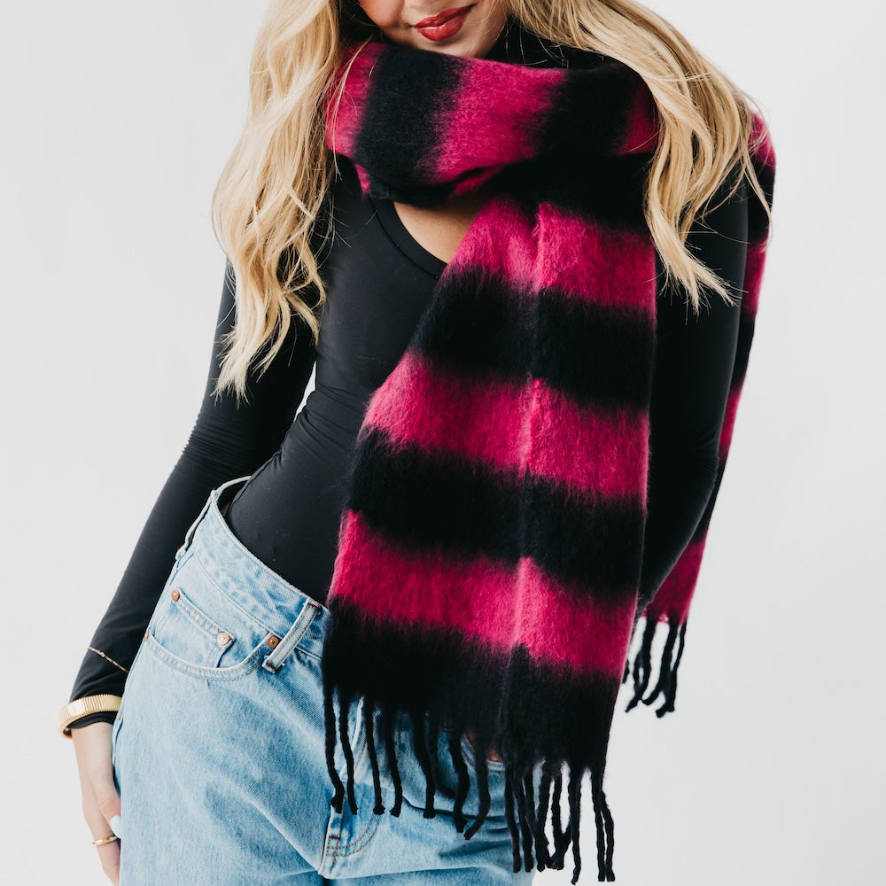Person wearing a black and pink plaid scarf with a plain background