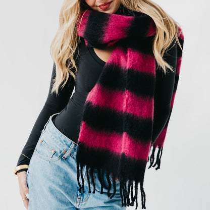 Person wearing a black and pink plaid scarf with a plain background