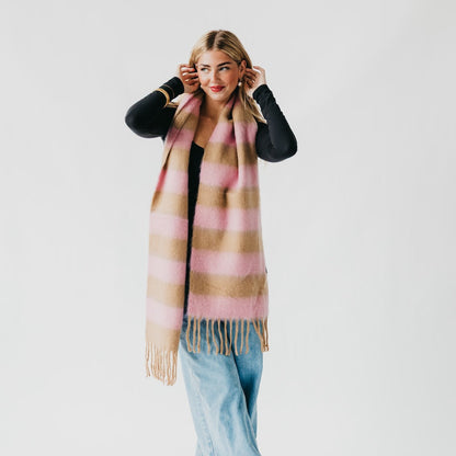 Woman wearing a pink and beige plaid scarf on a white background