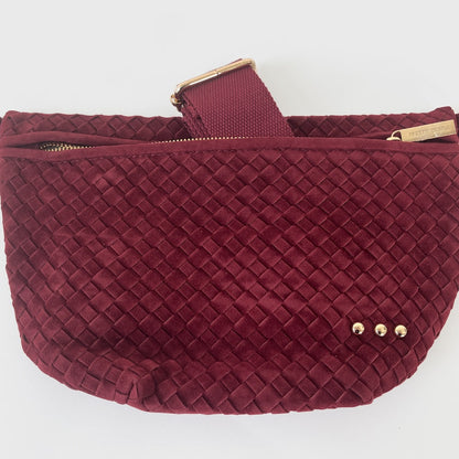 Maroon woven handbag with gold accents on a white background