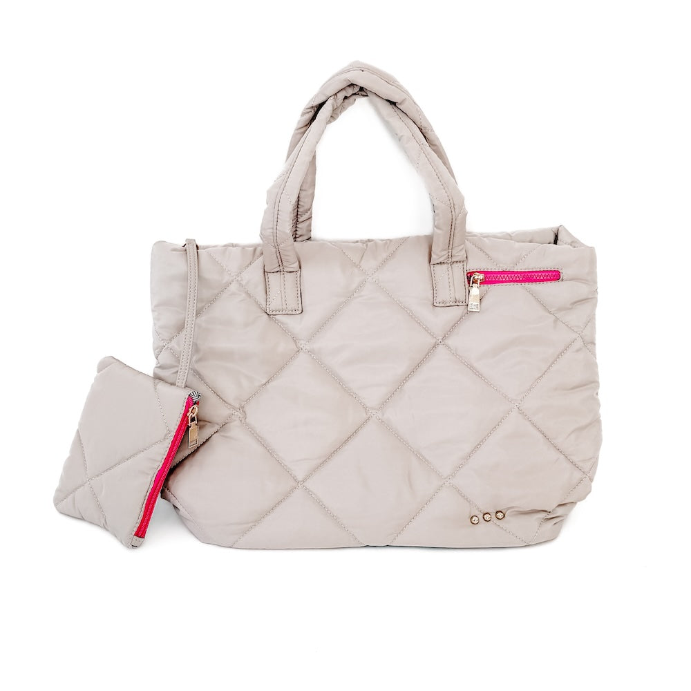 Quilted beige handbag with pink zippers on a white background