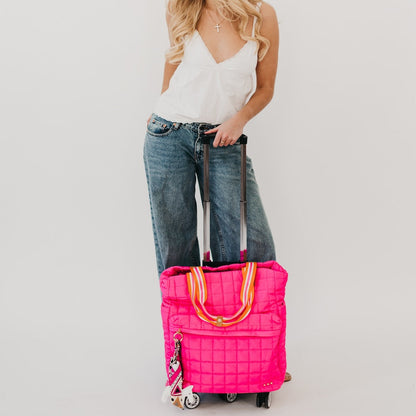 Person holding a pink suitcase with a white background