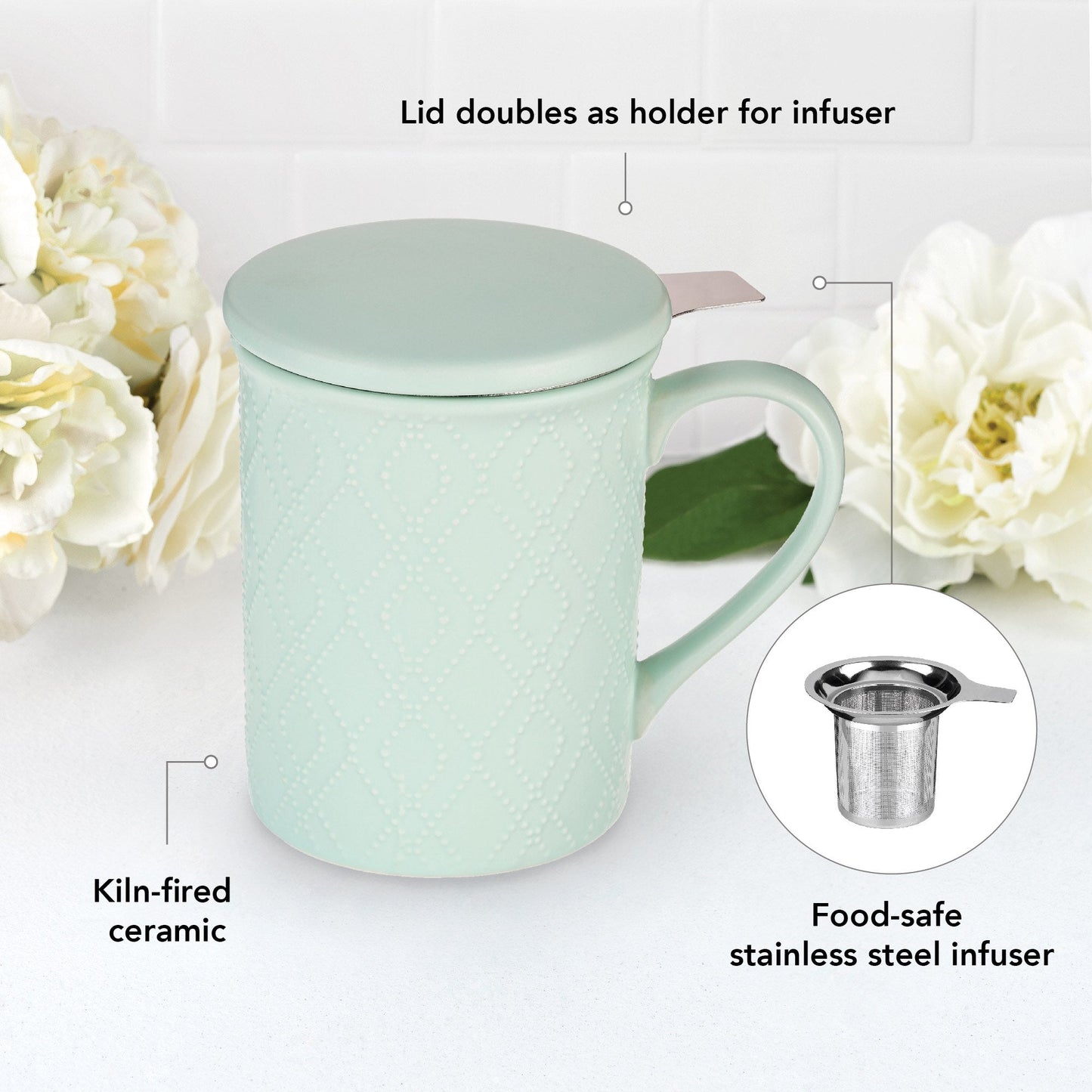 Mint green mug with lid and stainless steel infuser on a white background with flowers.