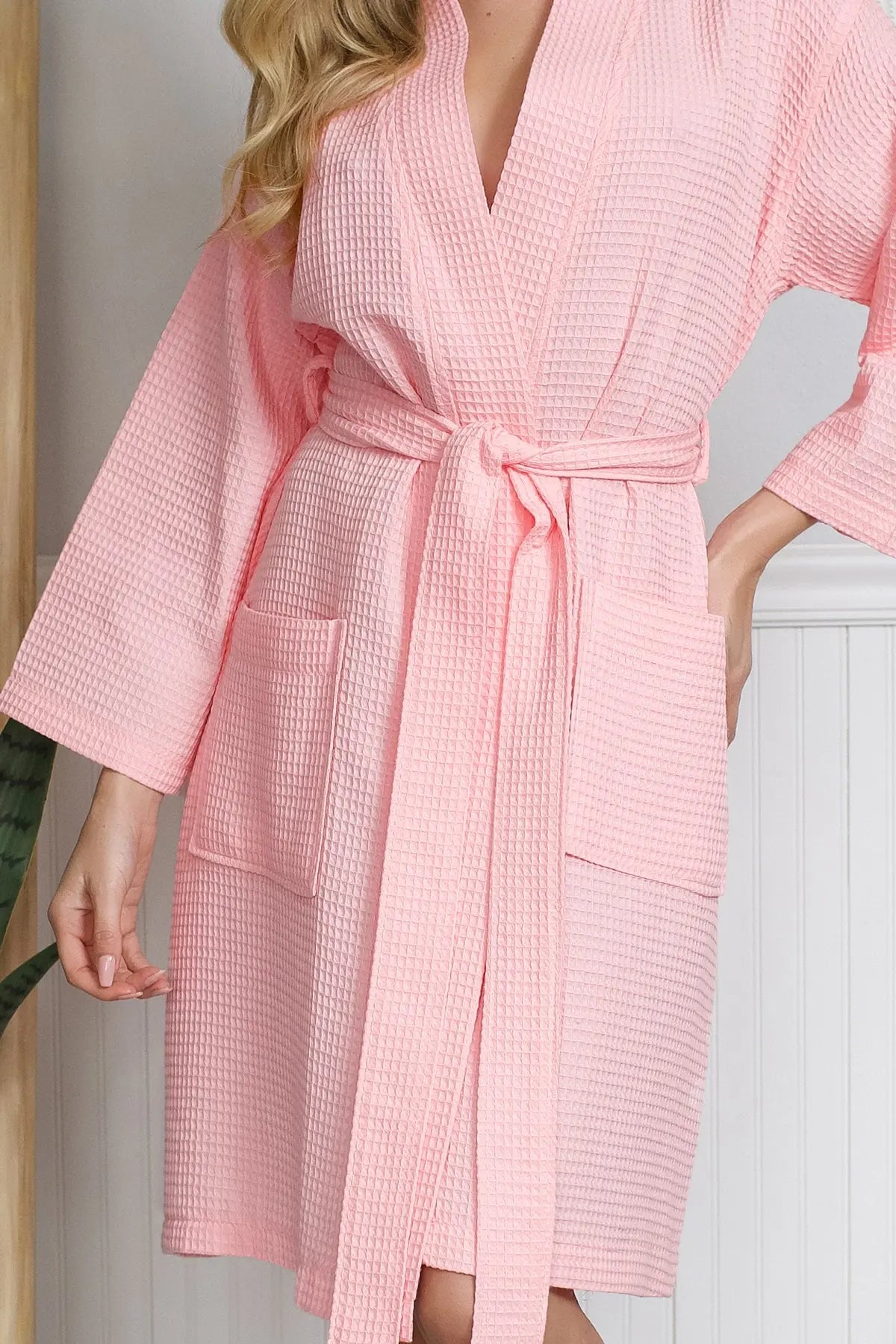 Person wearing a pink textured Waffle Kimono Knee-Length robe indoors.