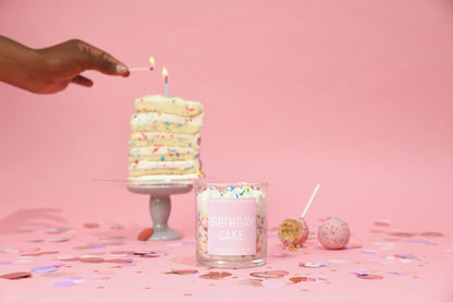 Candle labeled 'Birthday Cake' with a small cake and confetti on a pink background