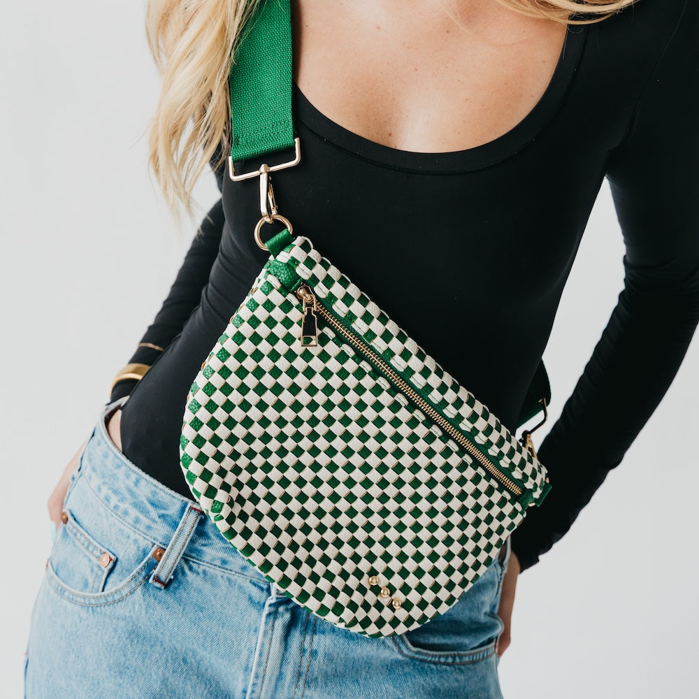 Person wearing a green and white checkered bag with a black strap.