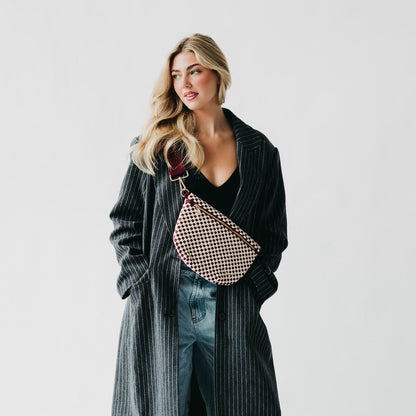 Woman holding a checkered bag against a plain background