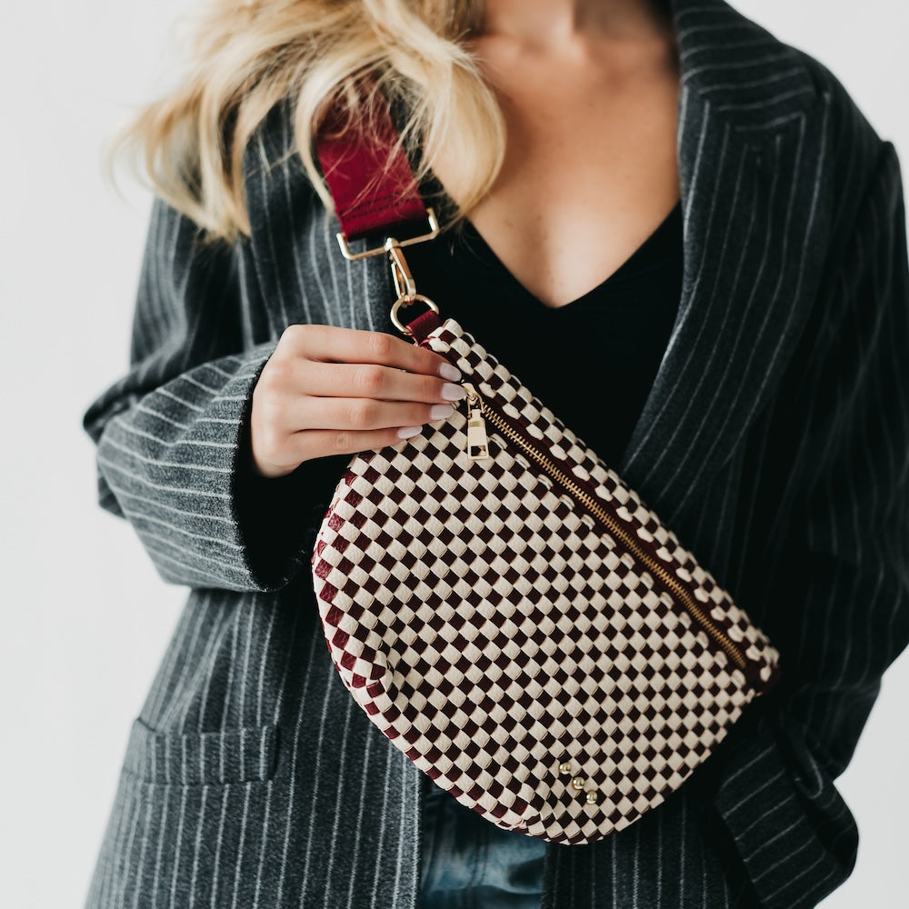 Person holding a checkered handbag with a plain background