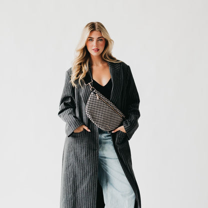 Woman holding a patterned handbag against a plain background