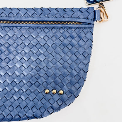 Blue woven clutch bag with gold zipper and hardware on a light background