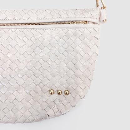 White woven handbag with gold zipper and hardware on a light gray background
