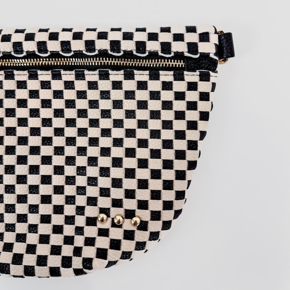Black and white checkered bag with gold studs on a light gray background