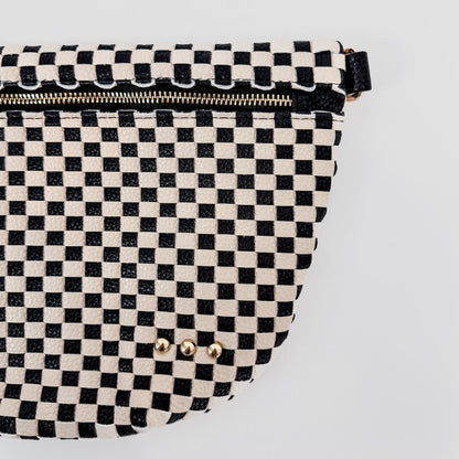 Black and white checkered bag with gold studs on a light gray background