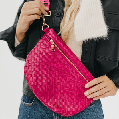 Person holding a pink woven bag with a white background