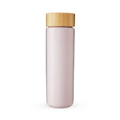 Pink tea infuser bottle with a wooden cap on a white background